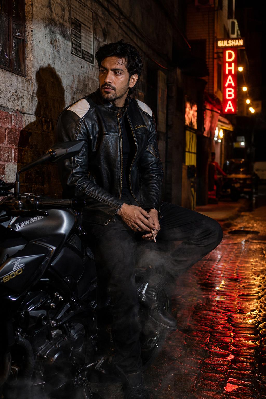 Model in LeatherJazz black racing jacket on a Kawasaki at night in a Mumbai alley
